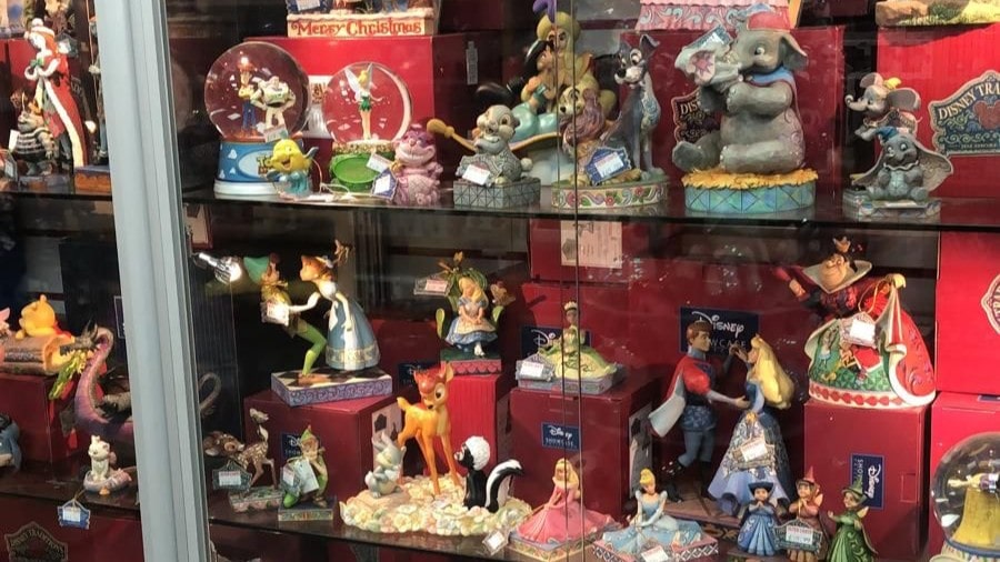 Top Disney collectible gift ideas for 2025 including Stitch plush, Belle figurine, and Warmies Mickey Mouse displayed in a festive gift setting