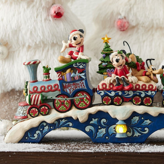 Disney Traditions Christmas figurines displayed with fairy lights and festive decorations